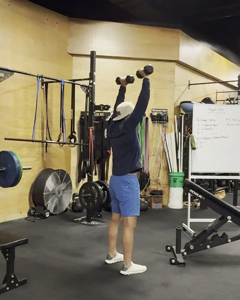 Matt Arnold coaching a dumbbell press in a gym