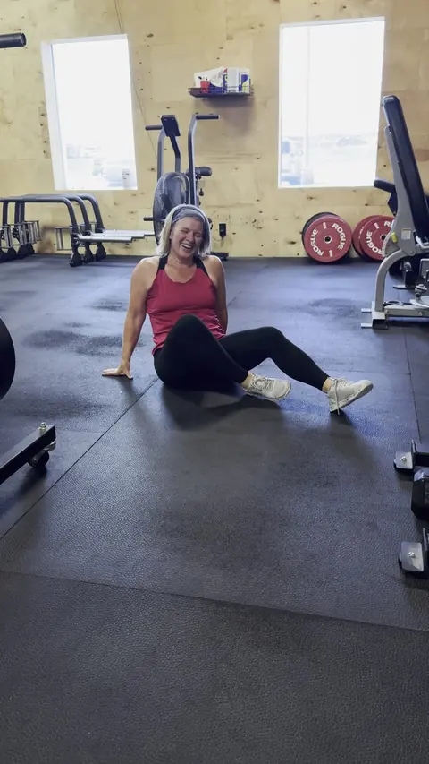 A woman laughing in a gym